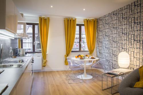 a kitchen with a table and chairs in a room at Les apparts du marché in Obernai