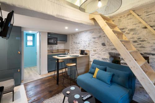 un salon avec un canapé bleu et une cuisine dans l'établissement Ty Color's, à Rennes