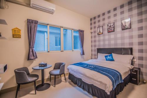 ein Schlafzimmer mit einem Bett und zwei Stühlen und einem Tisch in der Unterkunft Follow Me Travel Homestay in Ruisui