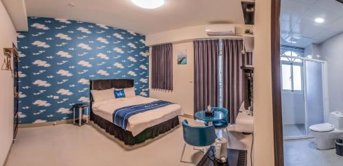 ein Krankenhauszimmer mit einem Bett mit Wolken an der Wand in der Unterkunft Follow Me Travel Homestay in Ruisui