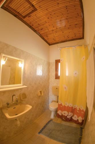 a bathroom with a sink and a shower curtain at Takis Apartments in Sidari