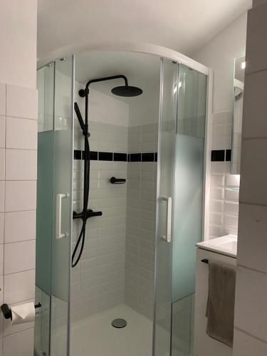 une douche avec une porte vitrée dans une salle de bain dans l'établissement Avocado Hôtel Restaurant, à Saint-Jeannet