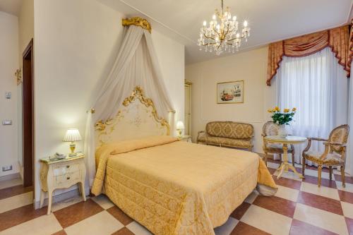 1 dormitorio con 1 cama, mesa y sillas en Hotel At Leonard, en Venecia