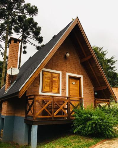 a small house with a gambrel roof at Chalés Amabilis in Monte Verde