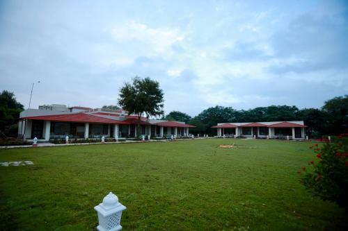 a large yard with a building and a grass field at Sariska Safari Lodge in Thāna Ghāzi