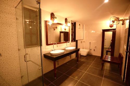 a bathroom with two sinks and a shower at Sariska Safari Lodge in Thāna Ghāzi