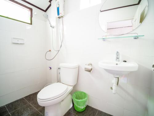 a white bathroom with a toilet and a sink at Harrys Sunset - Klong Nin Beach in Ko Lanta
