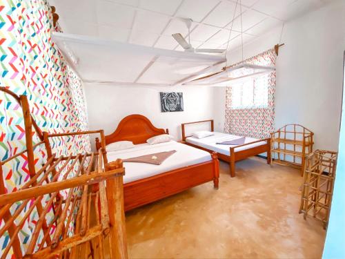 a bedroom with two beds and a staircase at Papaya Guest House Nungwi in Nungwi