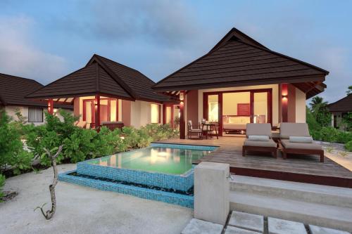 a villa with a swimming pool in front of a house at VARU by Atmosphere - Premium All Inclusive with Free Transfers in North Male Atoll