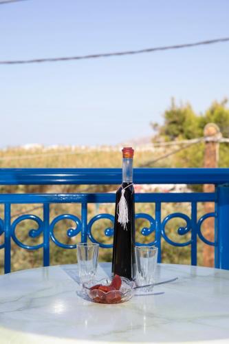 a bottle of wine sitting on a table with glasses at Flora Apartments & Studios in Agia Anna Naxos