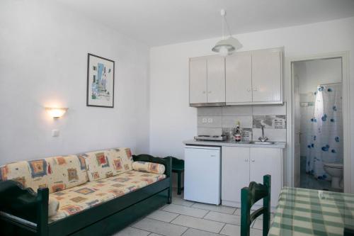 a living room with a couch and a kitchen at Flora Apartments & Studios in Agia Anna Naxos
