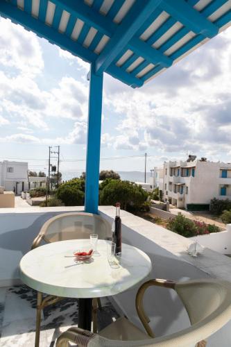 a table on a balcony with a bottle of wine at Flora Apartments & Studios in Agia Anna Naxos
