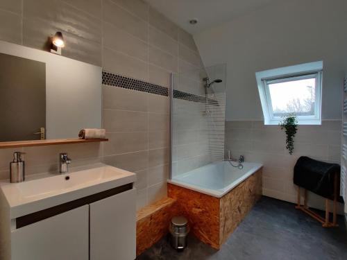 a bathroom with a bath tub and a sink at LV Holidays 2 in Savigny-en-véron