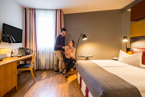 a man and a woman in a hotel room at Mercure Hotel Berlin Zentrum Superior in Berlin