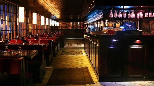 a restaurant with a bar with red tables and bottles at Spectra Inn Hotel in Cairo
