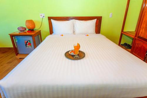 a bed with a tray with a drink on it at Lucky Homes in Phong Nha