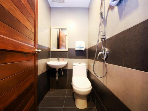 a bathroom with a toilet and a sink at Super OYO 910 Hills Residence in Kuching