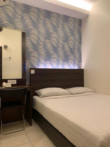a bedroom with a bed and a table with a mirror at The Regency Garden Hotel in Ipoh