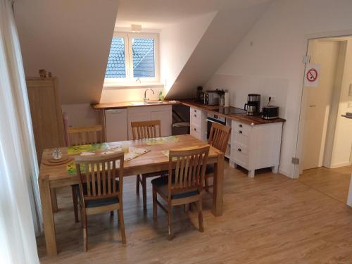 a kitchen with a wooden table and chairs in a room at Apartments Blütenweg in Leichlingen