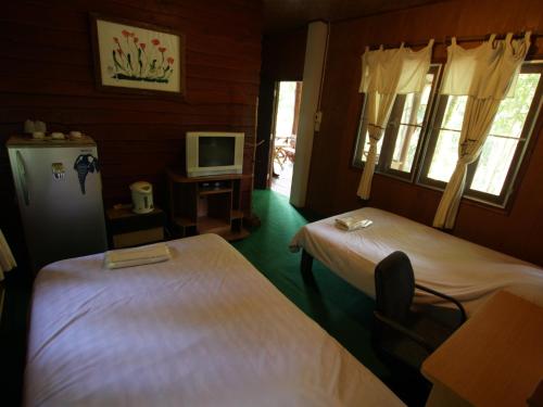 a room with two beds and a tv in it at The Thai Elephant Conservation Center Lampang in Lampang