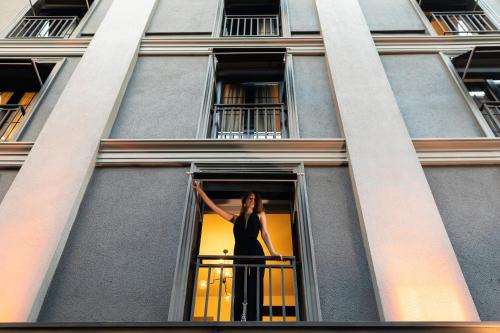 a woman standing on a balcony in a window at Nabu Hotel Karaköy in Istanbul