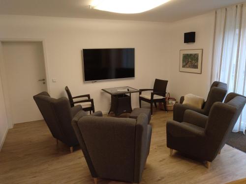 a living room with chairs and a flat screen tv at Apartments Blütenweg in Leichlingen
