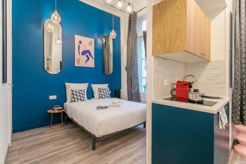 1 dormitorio con cama y pared azul en Apartments WS Marais - République en París