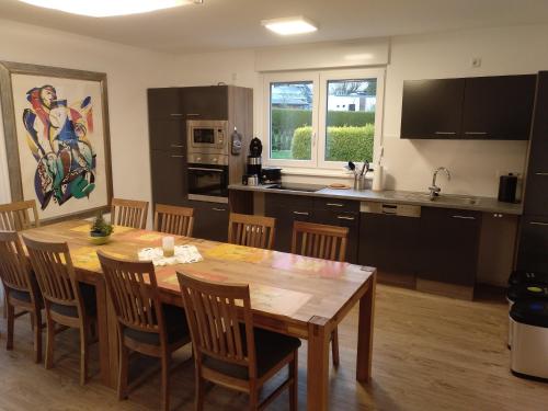 eine Küche und ein Esszimmer mit einem Holztisch und Stühlen in der Unterkunft Apartments Blütenweg in Leichlingen