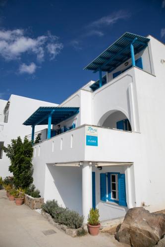 a white building with blue accents on it at Flora Apartments & Studios in Agia Anna Naxos