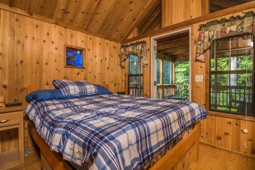 ein Schlafzimmer mit einem Bett in einem Blockhaus in der Unterkunft Family Cabin on 6 Acres with Lake Access and Hot Tub! in Springfield