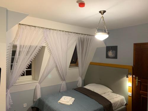 a bedroom with a bed and a window at Hotel Willa Starosty in Międzyrzecz