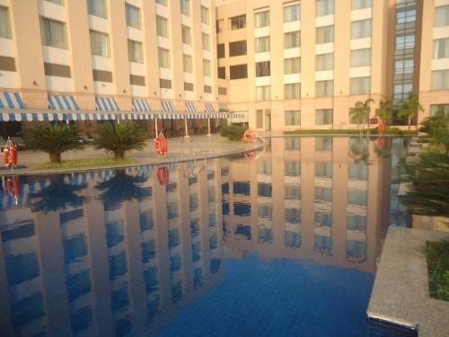a large building with a reflection in a pool of water at Radisson Blu Hotel Rudrapur in Rudrapur