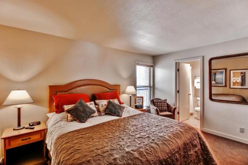 um quarto com uma cama grande e almofadas vermelhas em Bend Condo with Deck, Resort-Style Amenities and Views! em Bend