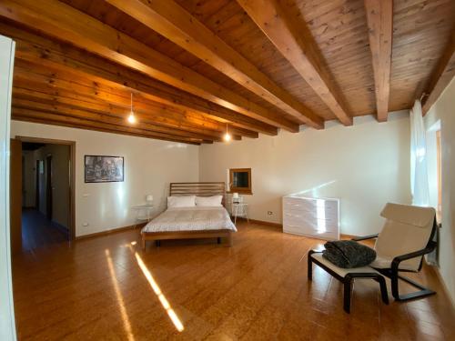 a bedroom with a bed and a chair in a room at Agriturismo Corte Moranda in Novaglie