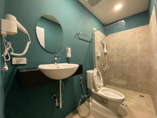 a bathroom with a sink and a toilet and a mirror at Nap Hotel in Chiang Rai