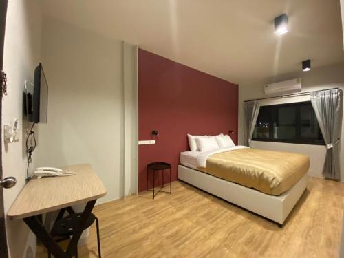 a bedroom with a bed and a desk in it at Nap Hotel in Chiang Rai
