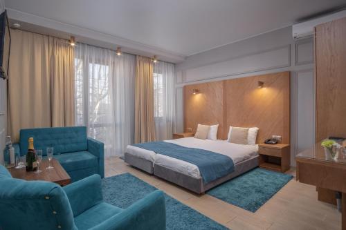 a hotel room with a bed and a blue couch at Boomerang Boutique Hotel in Odesa