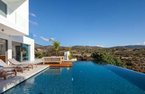 a swimming pool with a view of a house at Thalassa in Paphos City