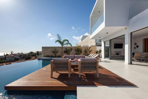 a patio with two chairs and a table and a pool at Thalassa in Paphos City