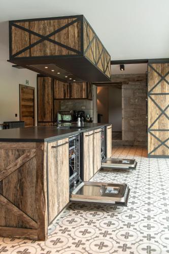 a kitchen with wooden cabinets and a counter top at Sous le Bois I in Érezée