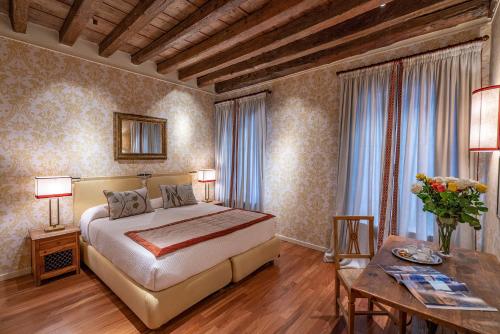 a bedroom with a king sized bed and a table at Ca' Belle Arti in Dorsoduro in Venice