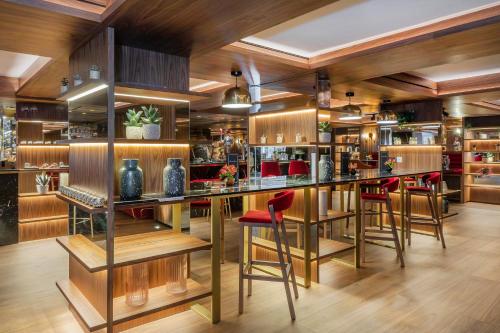 a bar in a restaurant with red stools at Meliá White House Hotel Apartments in London