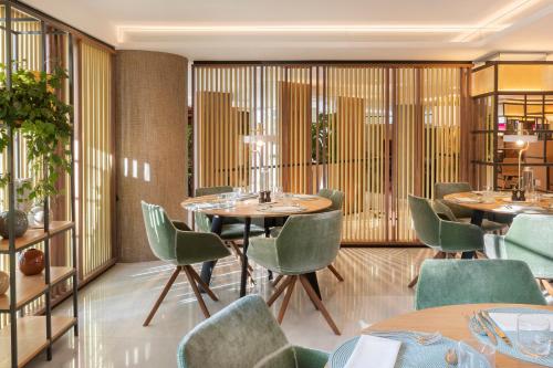 a restaurant with round tables and green chairs at Meliá White House Hotel Apartments in London
