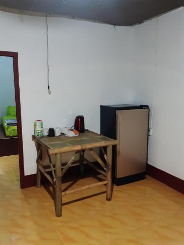 a wooden table in a room with a refrigerator at Som PalmGarden in Ko Lanta
