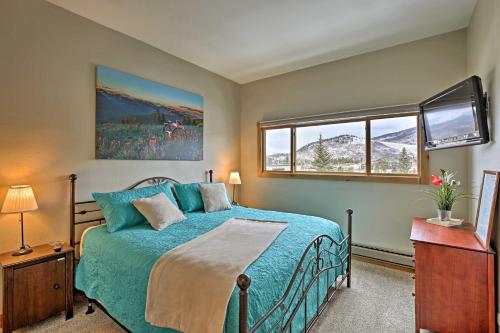 a bedroom with a blue bed and a window at Mtn-View Condo with Hot Tub Access in Dillon! in Dillon