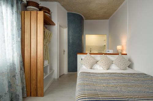 a bedroom with a bed and a mirror in a room at Vallas Apartments & Villas in Firostefani