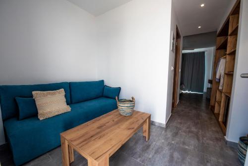 a living room with a blue couch and a wooden table at Summer Village of Hippokrates - Adults only in Marmari