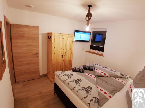 a bedroom with a bed and a flat screen tv at DAVID SUITEN in Mauterndorf