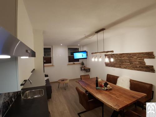 a kitchen and dining room with a wooden table at DAVID SUITEN in Mauterndorf