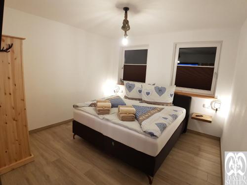 a bedroom with a large bed with two windows at DAVID SUITEN in Mauterndorf